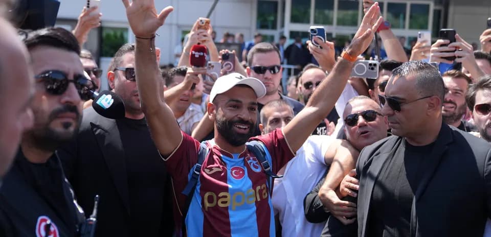 Player greeting fans surrounded by crowd and security