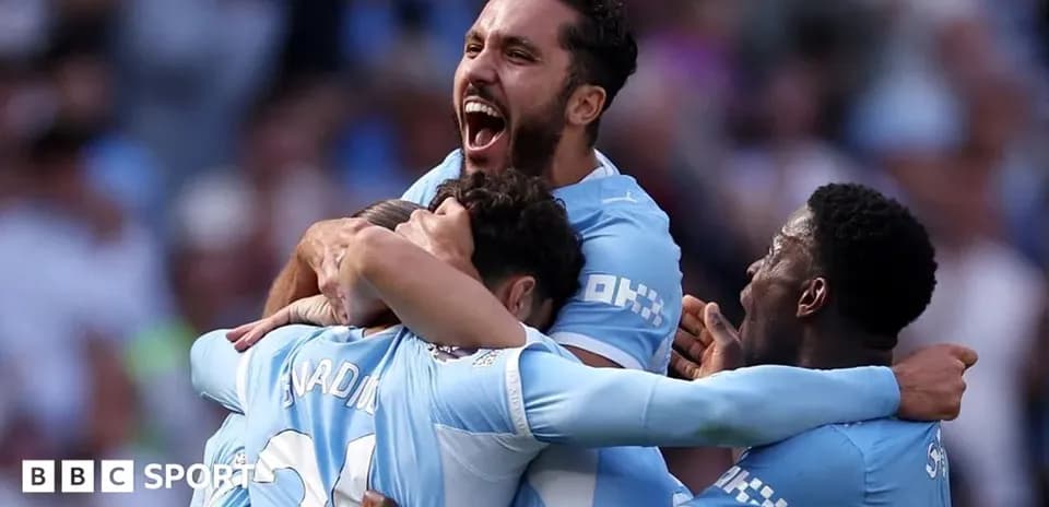 Players celebrating a goal in Manchester City kit