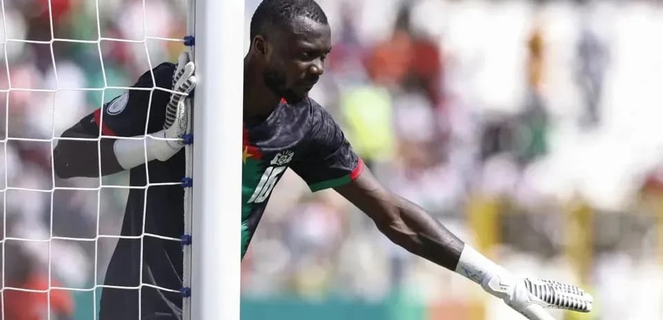 Goalkeeper signaling during a match near the goalpost
