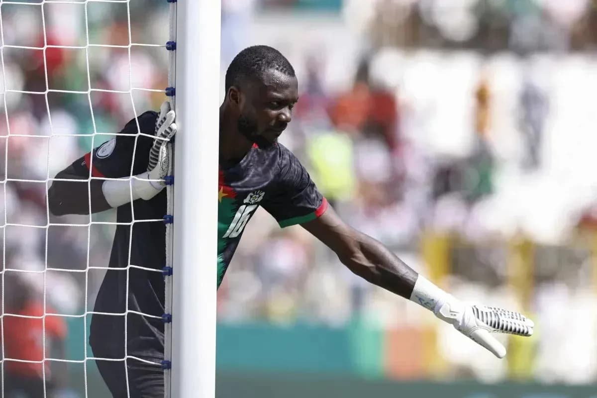 Goalkeeper signaling during a match near the goalpost