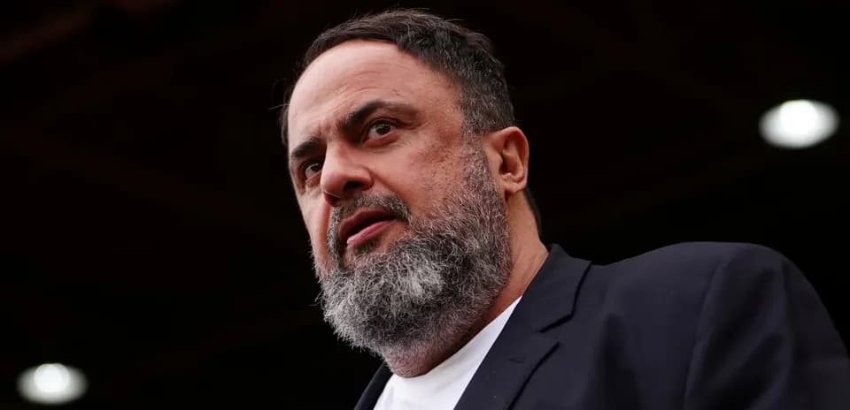 Man with beard speaking at a podium