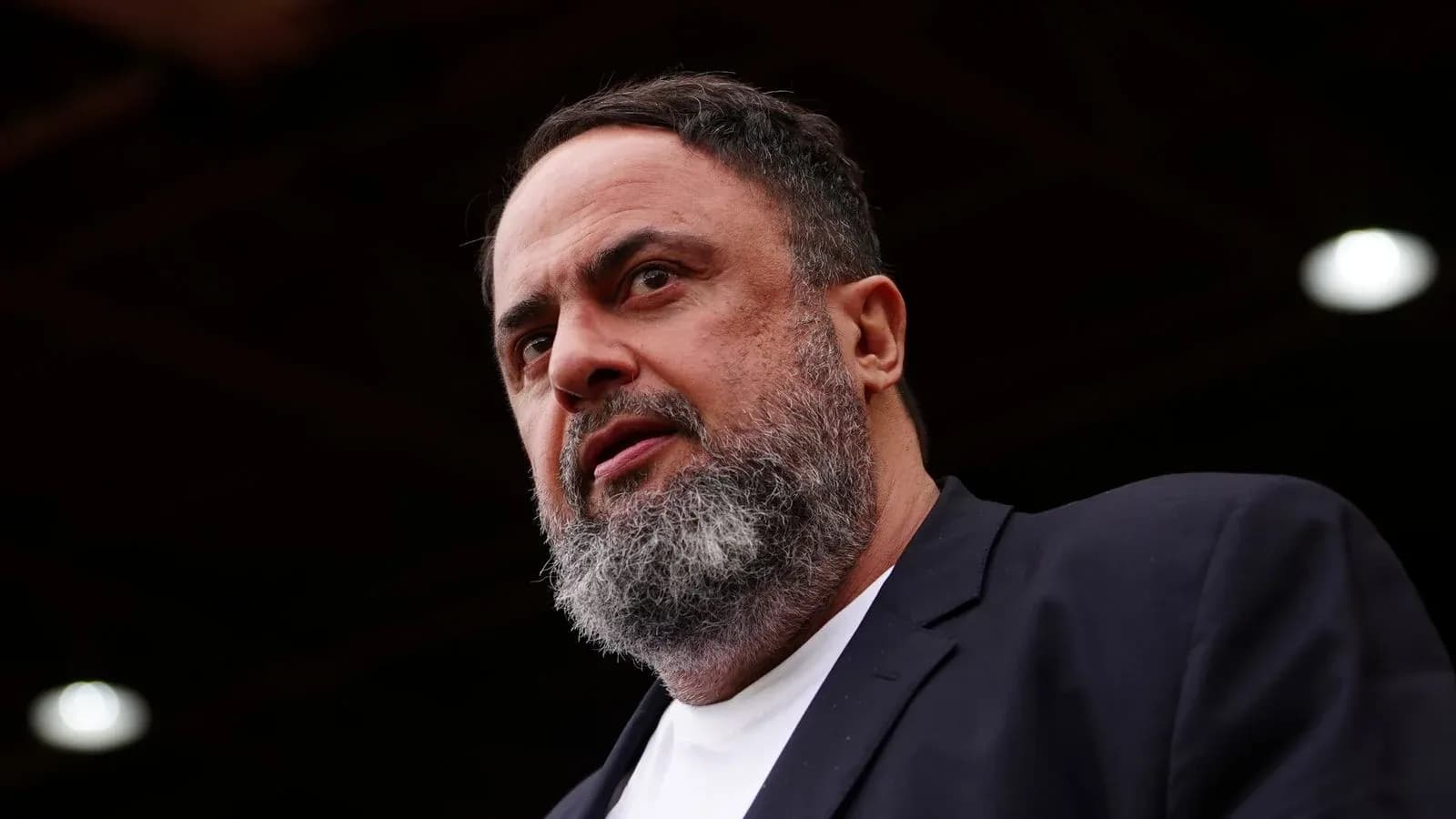 Man with beard speaking at a podium