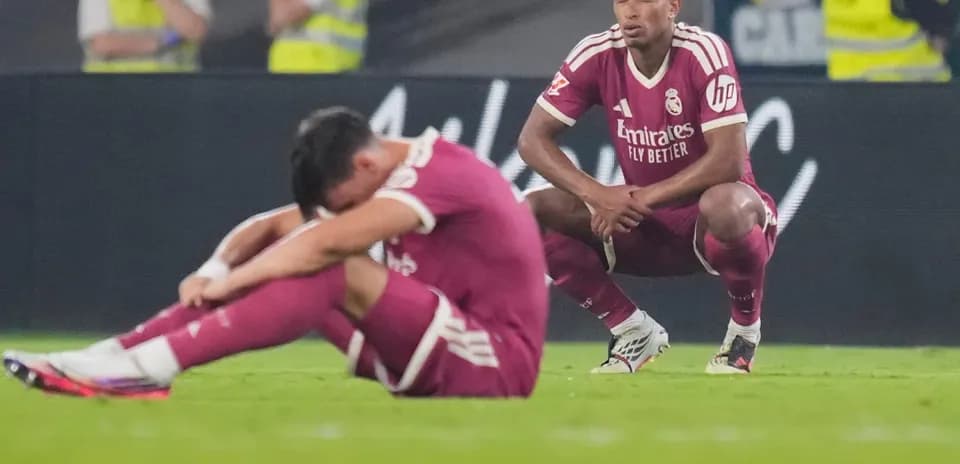 Real Madrid players seated on pitch after match