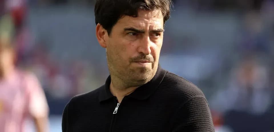 Coach observing players during pre-match warm-up