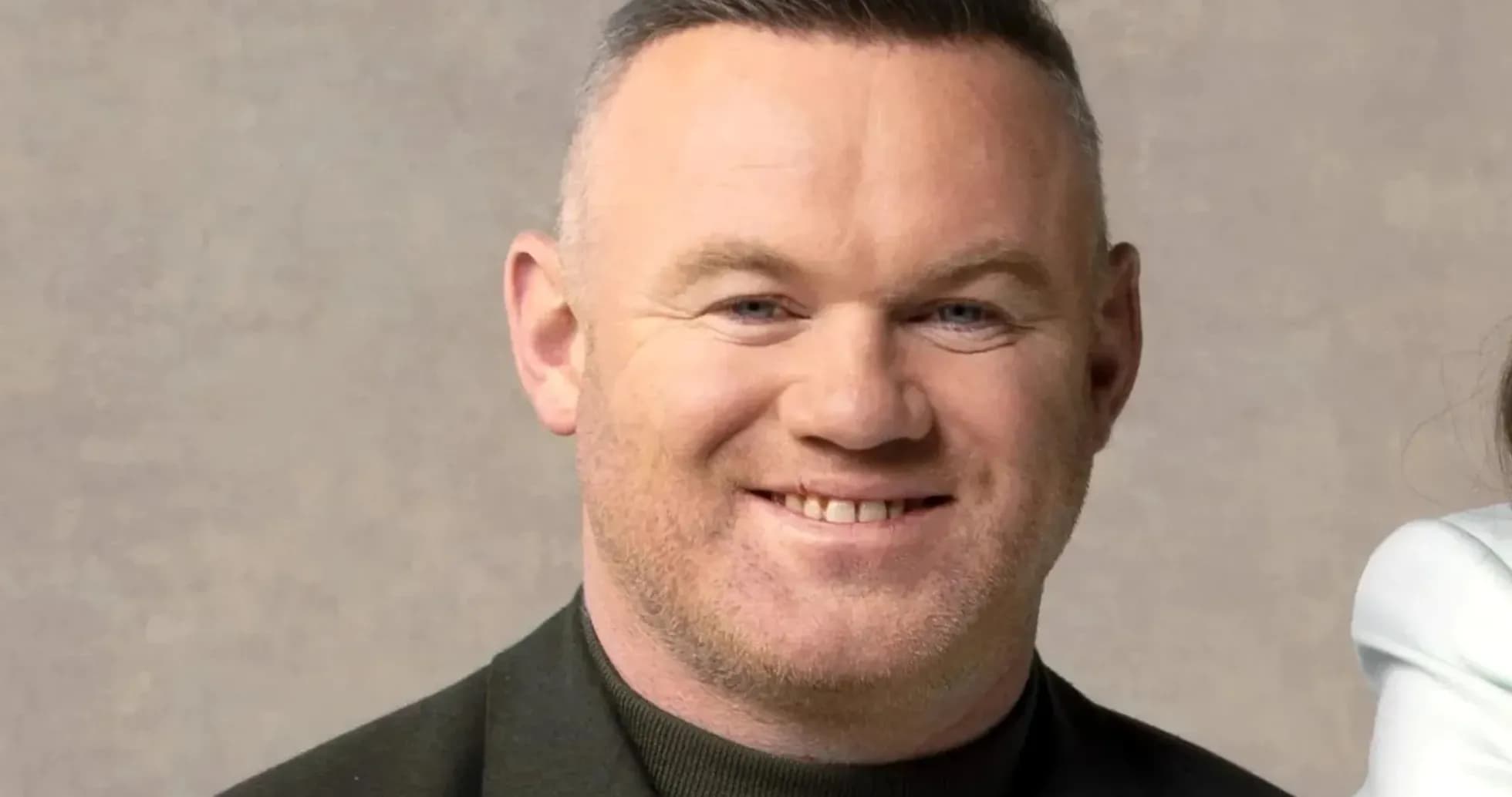 Man smiling in a formal outfit against a neutral background