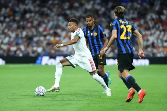 Kylian Mbappé dribbling past defenders during match