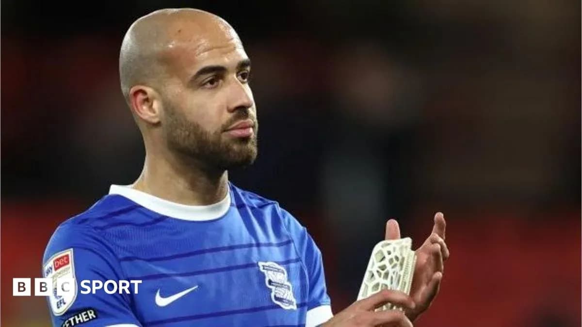 Player in blue jersey applauding fans after match