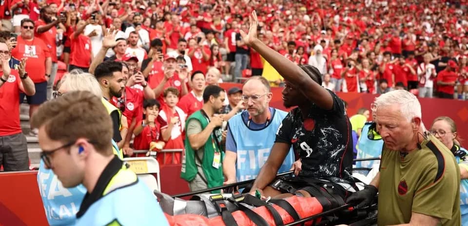 Player being carried on stretcher with crowd cheering