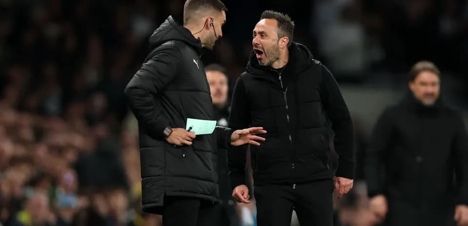 Two coaches discussing animatedly on the sideline