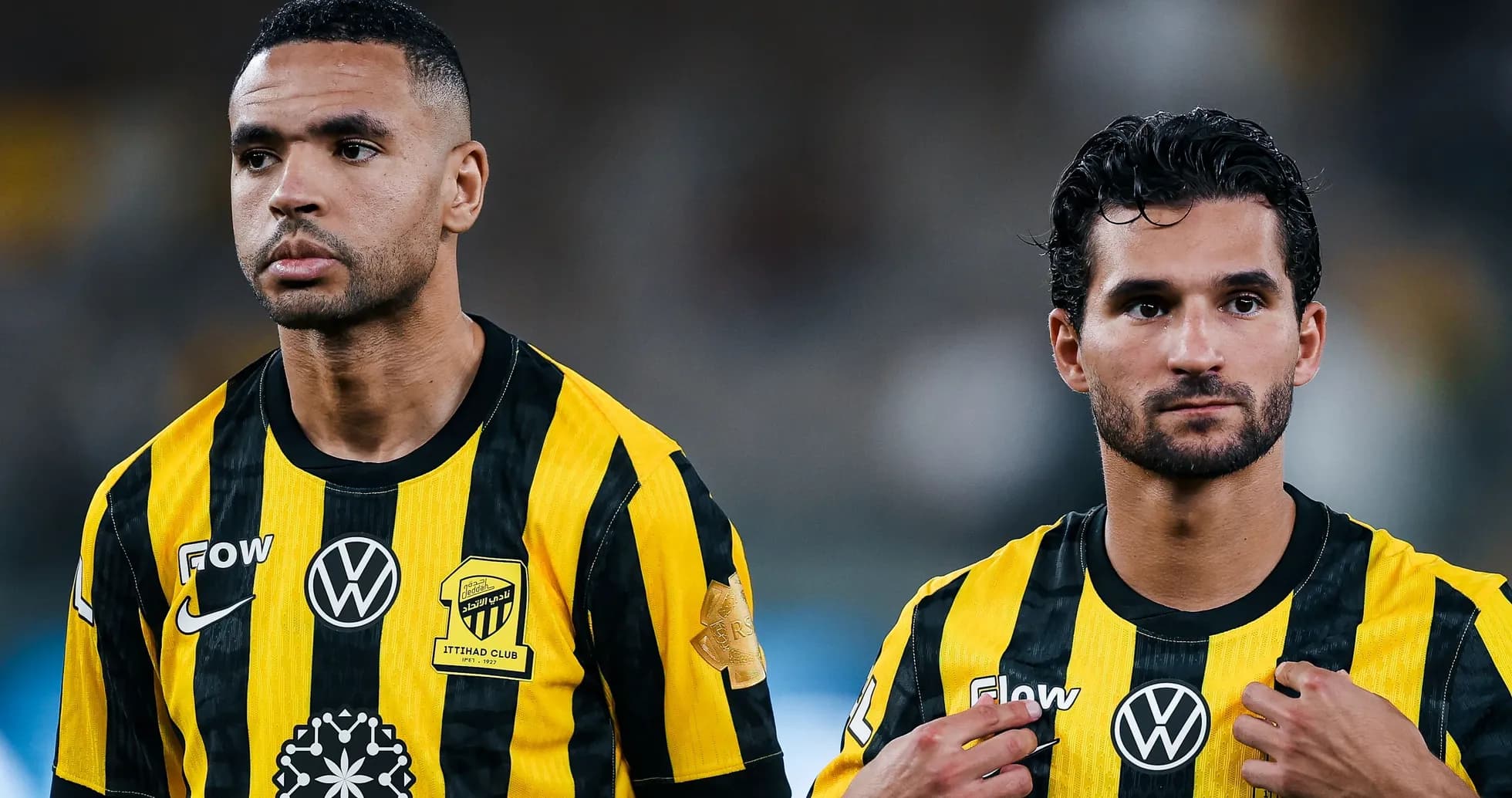 Two players wearing black and yellow team jerseys