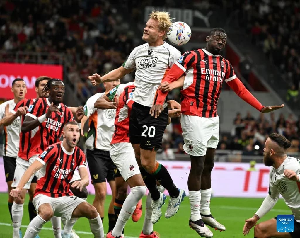 Players contesting a header during AC Milan match