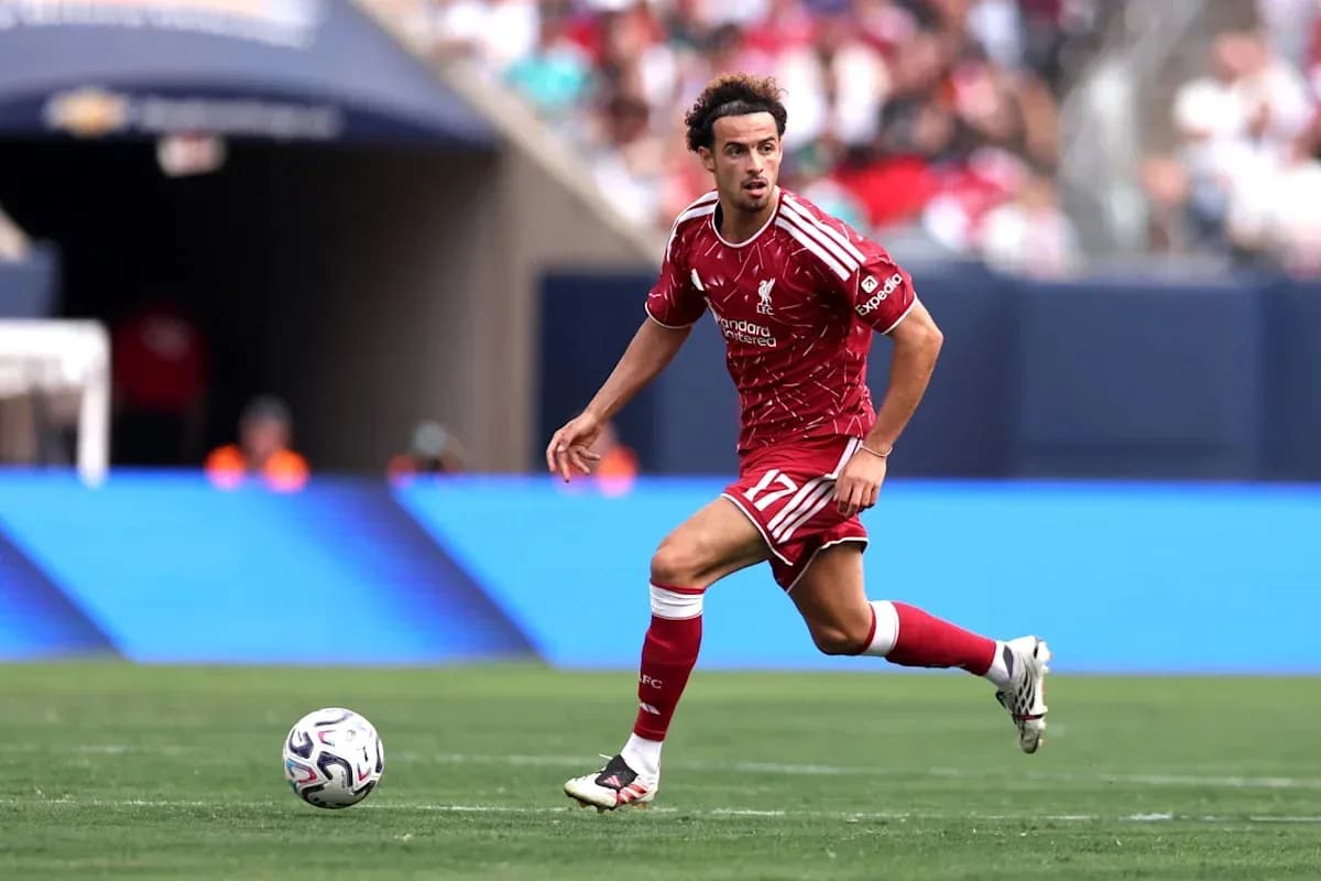 Player in Liverpool kit dribbling ball on field