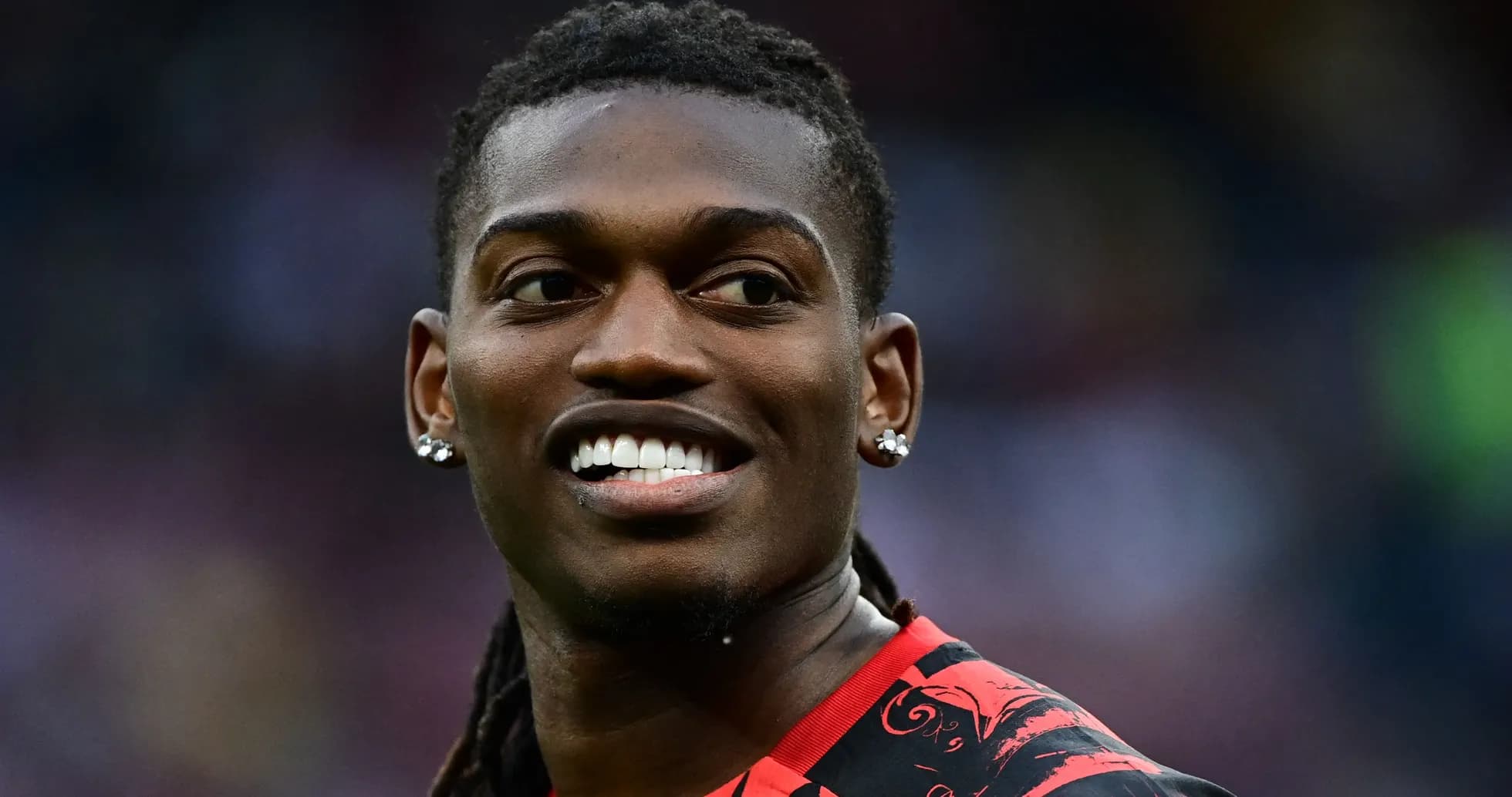 Player smiling while wearing a red and black jersey