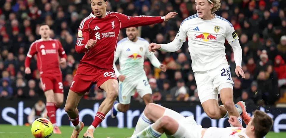 Liverpool player evading challenge from Leeds players