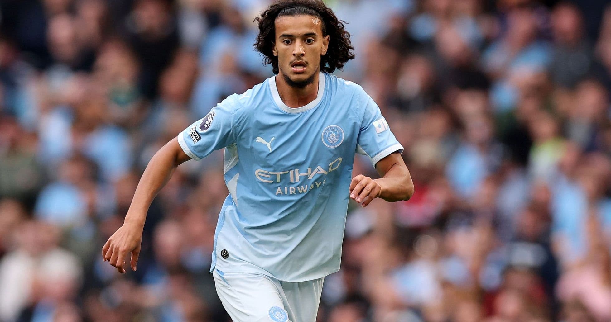 Player running on the pitch in Manchester City kit