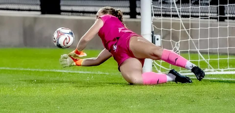 Goalkeeper diving to save the ball in match