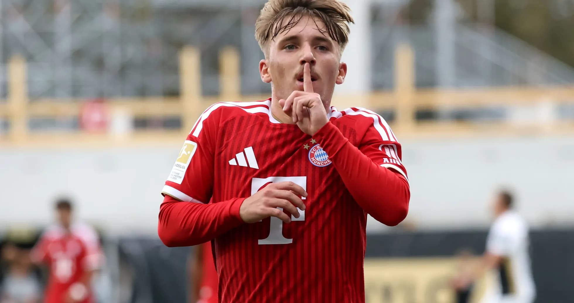 Player in red jersey signaling silence after scoring