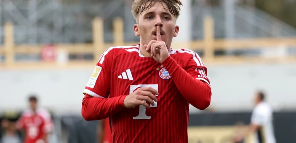 Player in red jersey signaling silence after scoring
