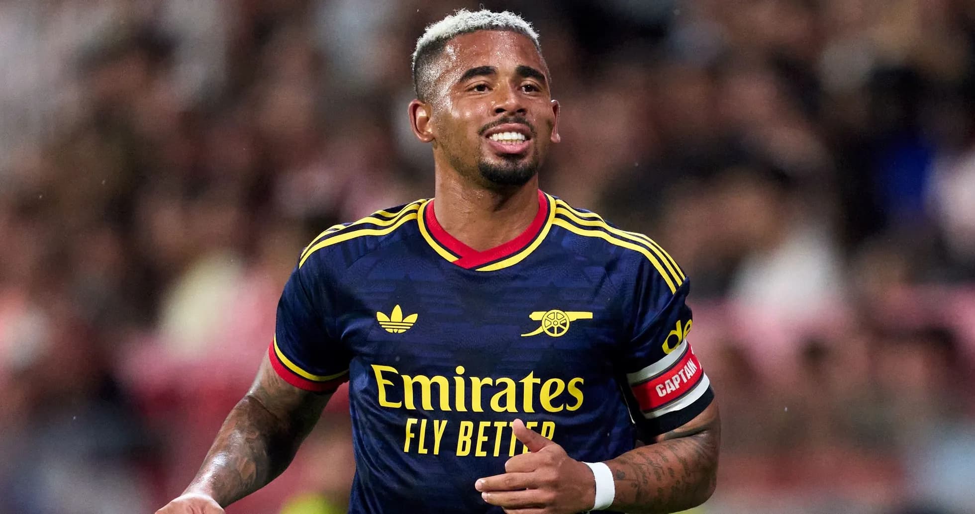 Player celebrating during match wearing Arsenal jersey