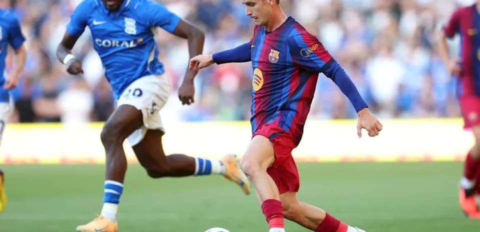 Barcelona player dribbling past Birmingham defender