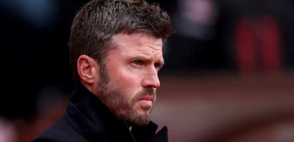Man in black coat looking thoughtfully at field
