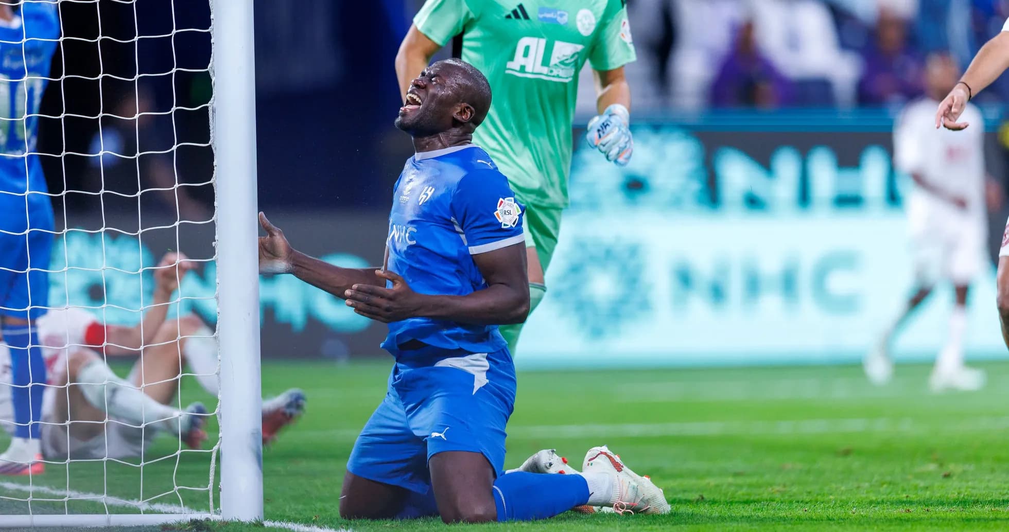Player kneeling in front of goal post during match