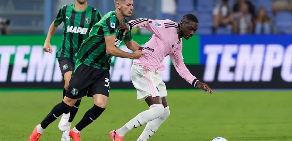 Sassuolo player challenges Juventus opponent for ball