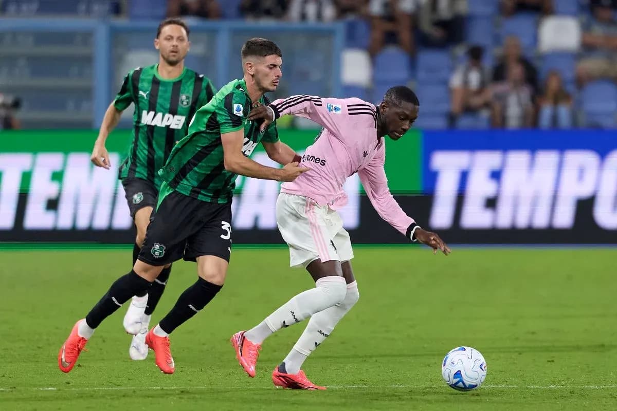 Sassuolo player challenges Juventus opponent for ball