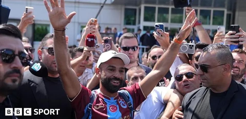 Player greeting fans outside stadium with raised hands