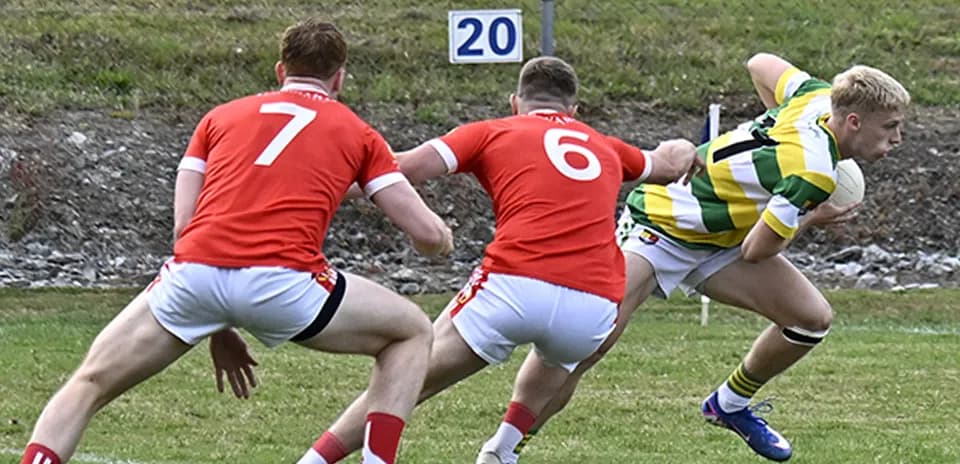 Player in green and yellow evading two defenders