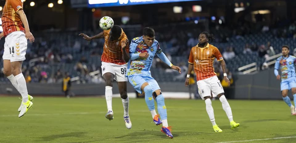 Players competing for the ball in USL Championship