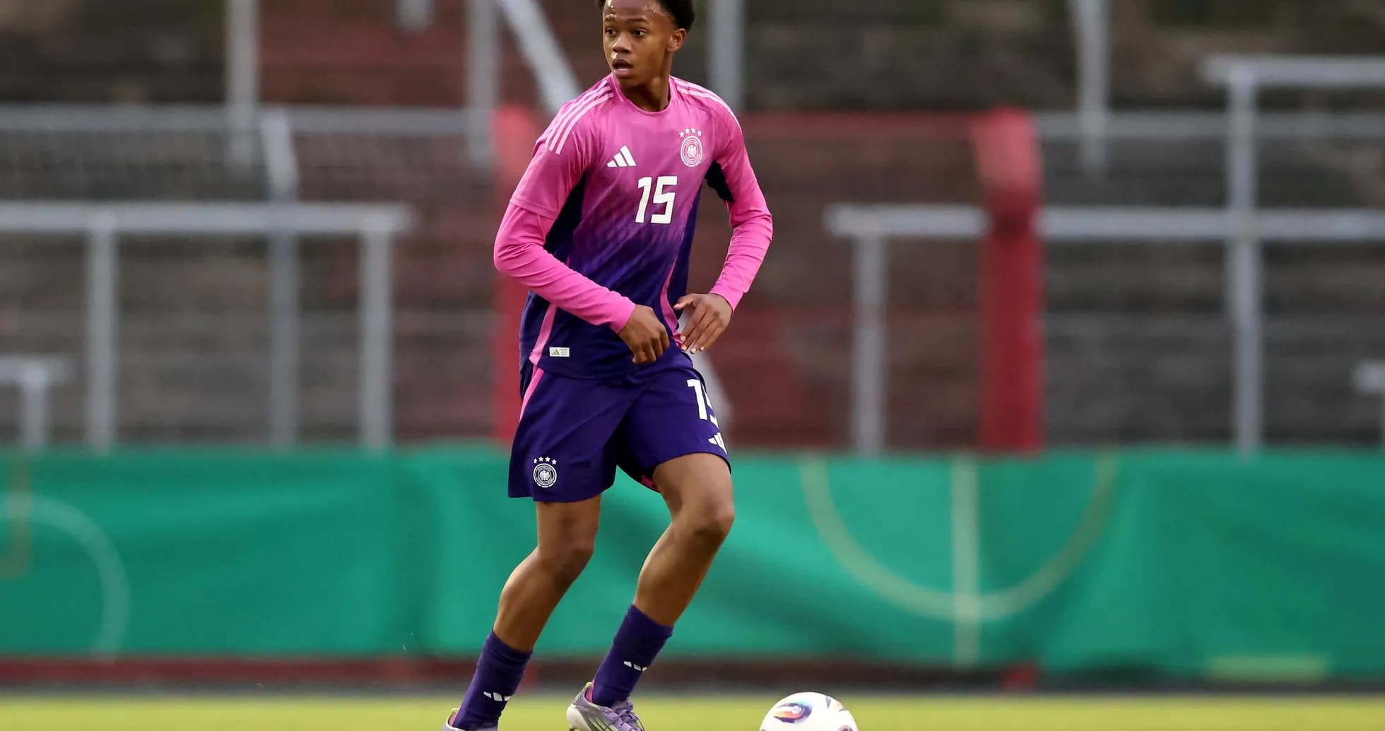 Player in pink and blue kit during training session