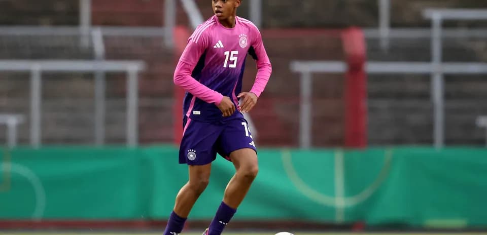 Player in pink and blue kit during training session