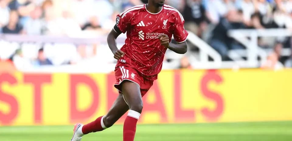 Player in red kit running on the pitch
