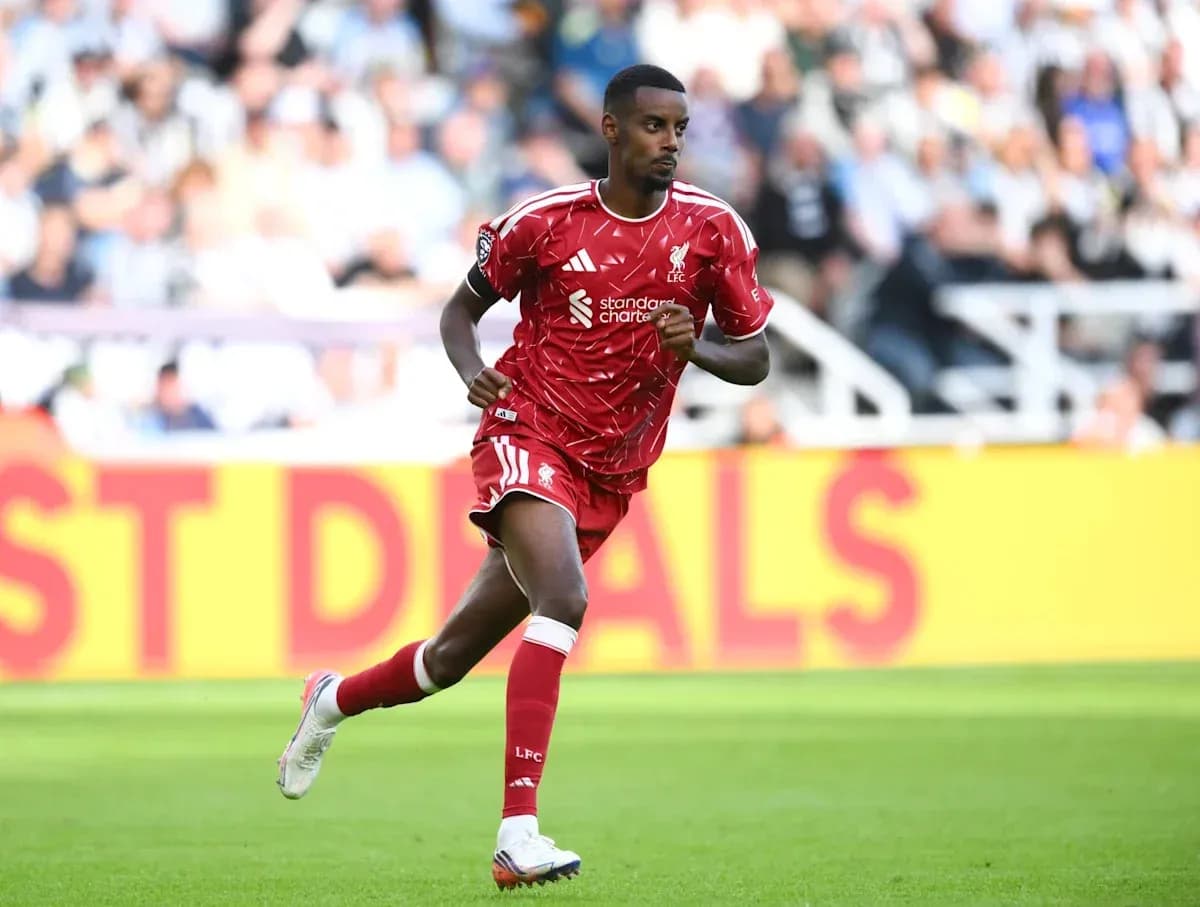 Player in red kit running on the pitch
