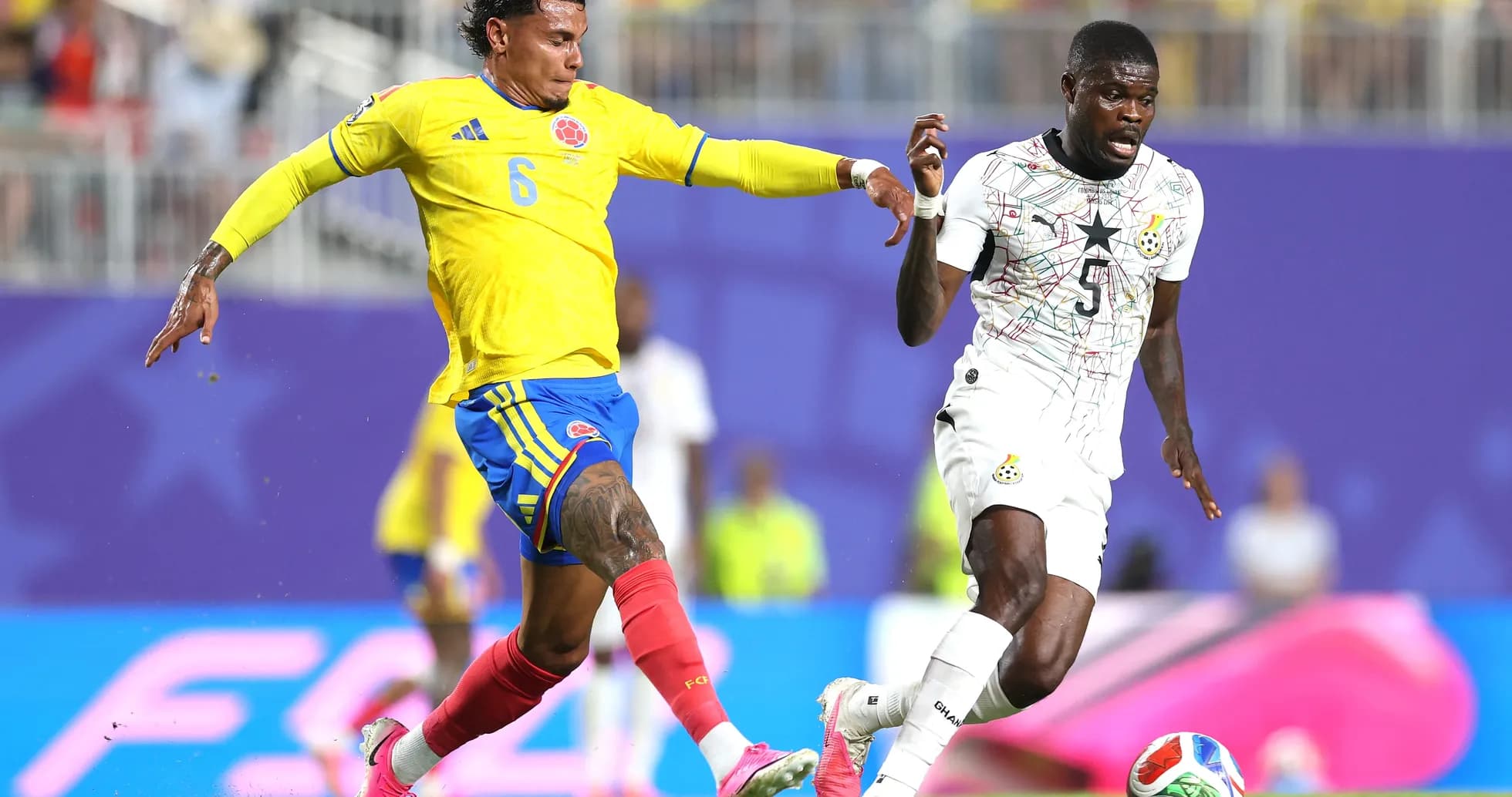 Colombian player tackles Ghanaian opponent during match