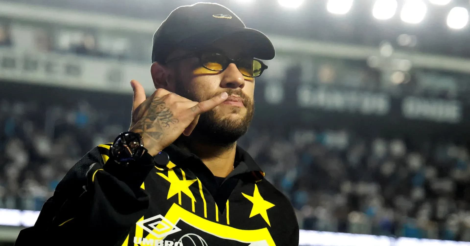 Person in sunglasses making a gesture at event