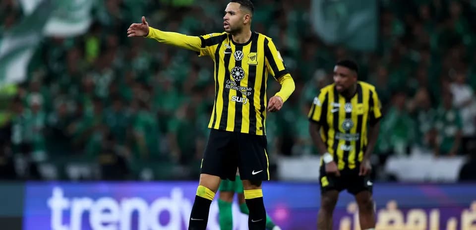 Player in yellow and black uniform directing teammates on field