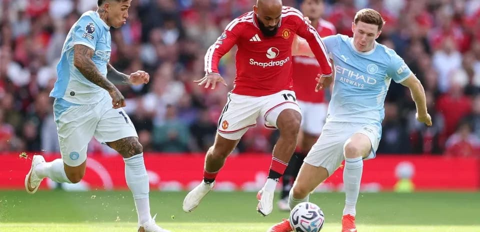 Manchester United and Manchester City players contesting for the ball