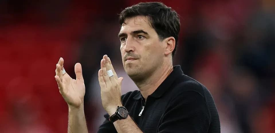 Coach applauding fans in stadium after match