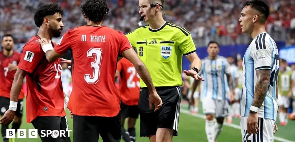Players and referee discussing during football match