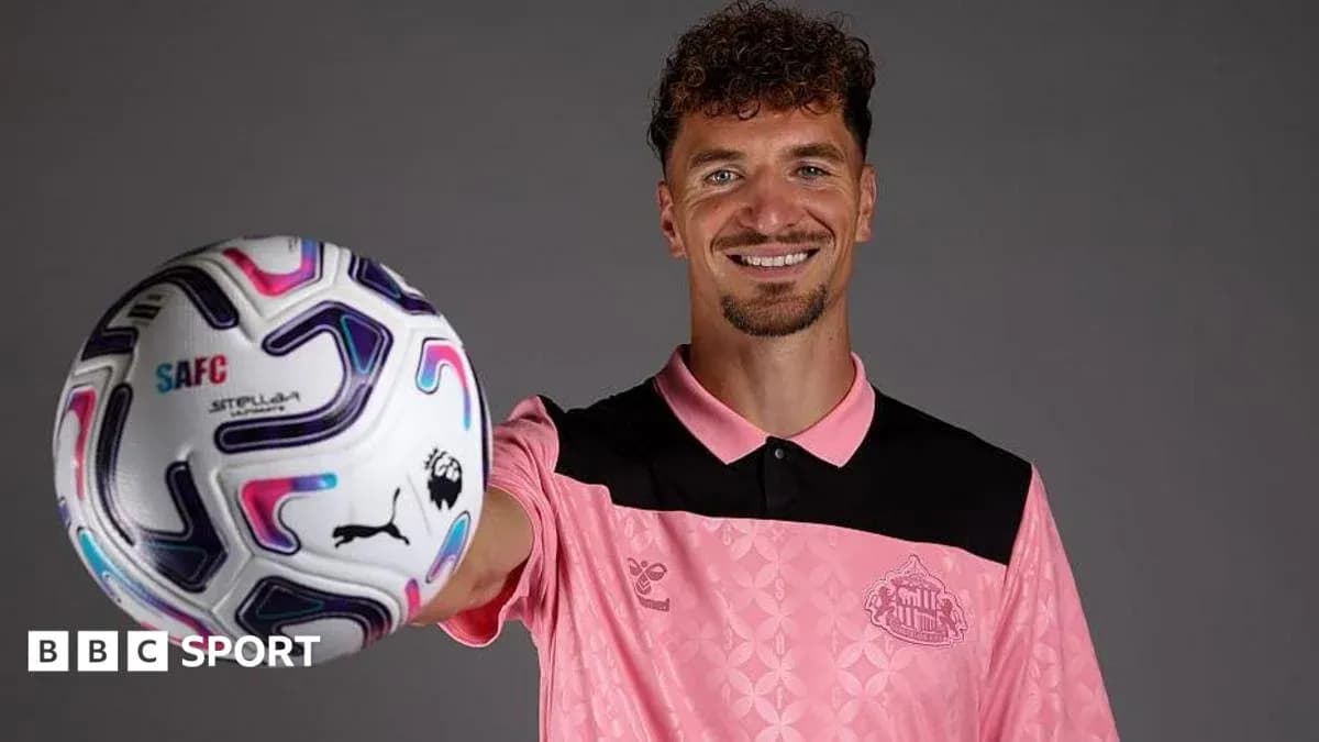 Player holding a football while smiling