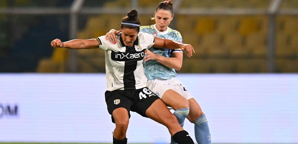 Parma W player challenged by Juventus W opponent