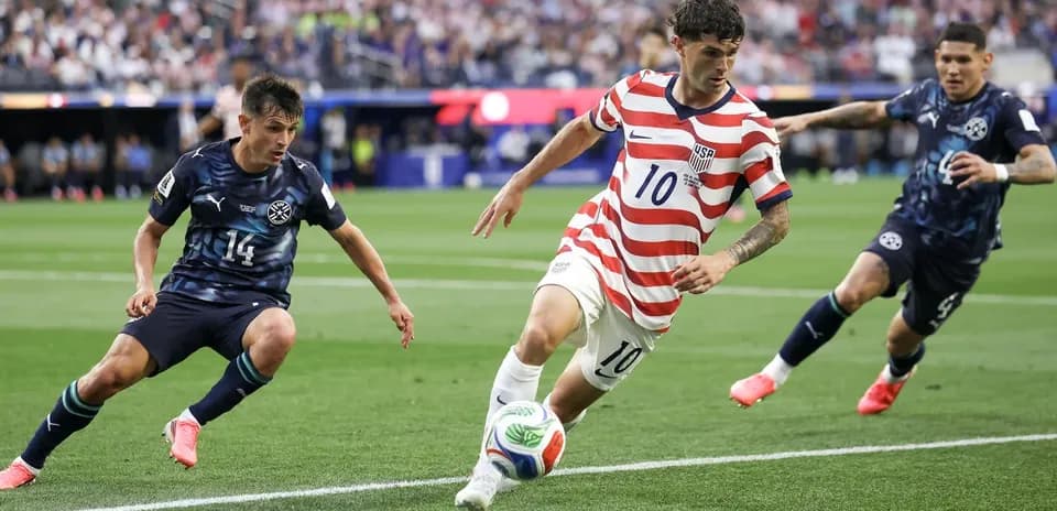 US player dribbling past opponents during match