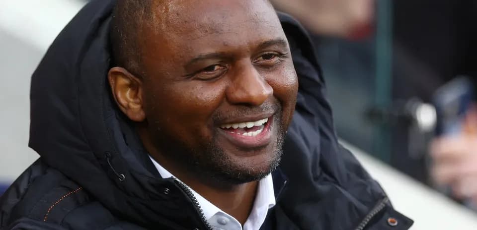 Person smiling while seated in a stadium