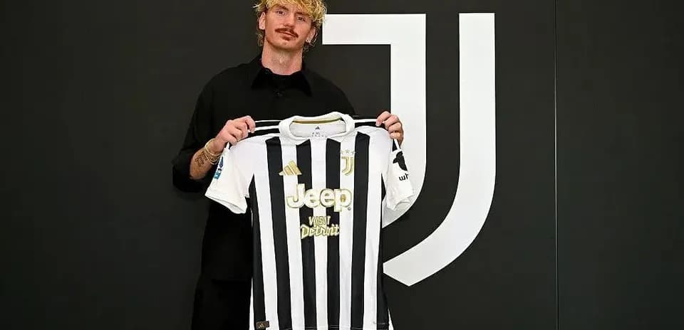 Player holding Juventus jersey at press conference