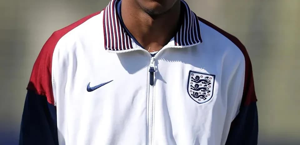Player wearing England training jacket on pitch