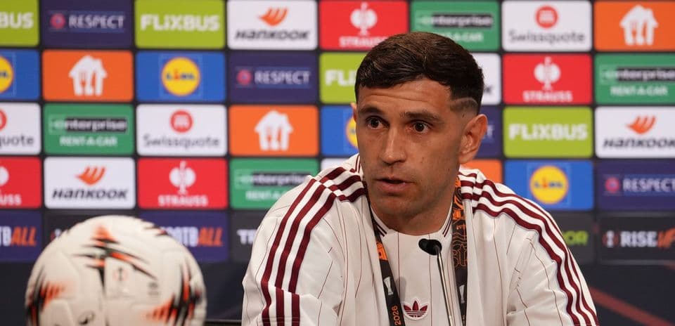 Player speaking at press conference with football