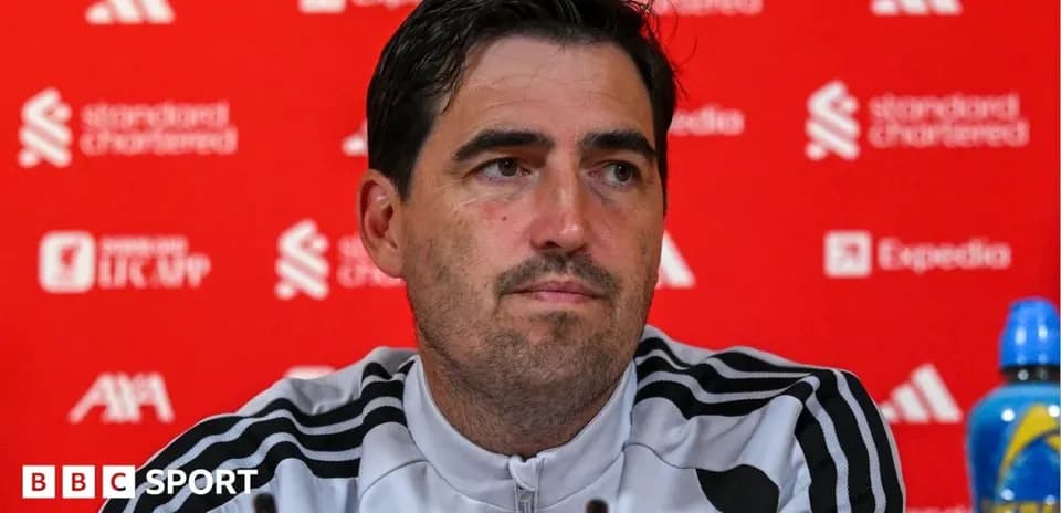 Manager speaking at press conference with team logo backdrop