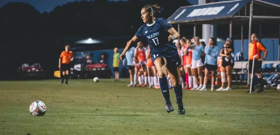 Player in blue jersey kicking soccer ball on field